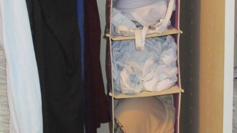 Ein Wäschesortierer für Slip-BH-Sets hängt im Schrank, strukturiert und sortiert die Wäsche für einfachen Zugriff.