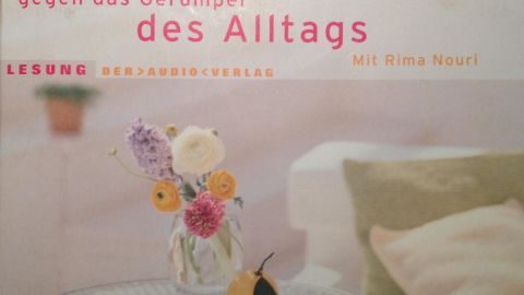 Ein Buch über Feng Shui gegen das Gerümpel des Alltags liegt auf einem Tisch, umgeben von einer gemütlichen Atmosphäre.
