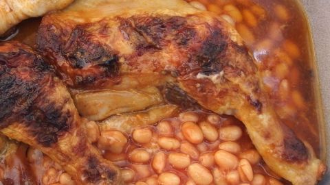 Geflügelkeulen braten in einer schmackhaften Bohnenlösung, umgeben von einer goldbraunen Sauce und köstlichem Aroma.