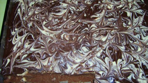 Ein schokoladiger Karamellkuchen mit swirled Musterung steht in einer Backform auf einer Arbeitsfläche, bereit zum Servieren.