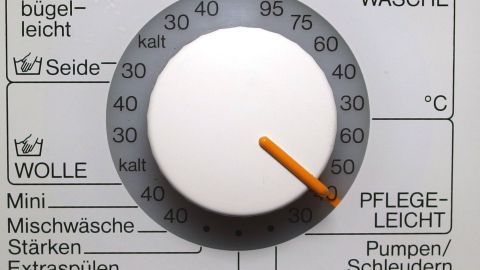 Ein Waschmaschinenregler zeigt die Einstellung von 40 Grad für Pflegeleichtwäsche an, um empfindliche Textilien schonend zu waschen.