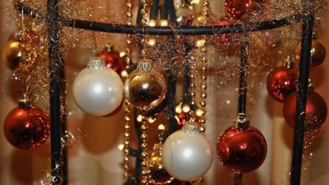 Ein dekorativer Weihnachtsbaumersatz schmückt sich mit glänzenden Kugeln und Lichtern in festlicher Umgebung.