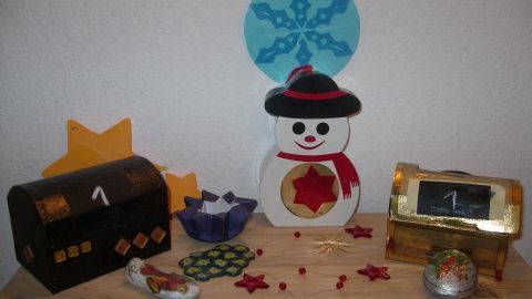 Bunte Adventskalender stehen auf einem Tisch, sanfte Weihnachtsdekoration, um die Vorfreude auf Weihnachten zu fördern.