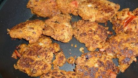 Reistaler mit Sesamsaat bräunen in einer Pfanne, um einen knusprigen, goldbraunen Snack zu kreieren.