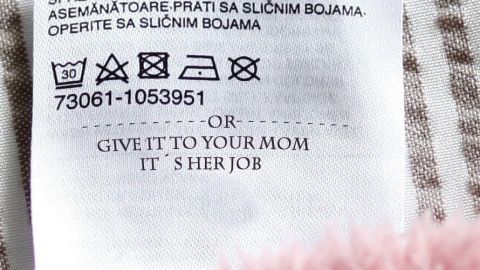 Das Pflegeetikett zeigt Wasch- und Pflegehinweise für ein Textil, darunter die Anweisung: „Give it to your mom. It's her job.“