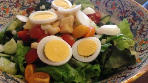 Bunter Salat in einer dekorativen Schüssel mit frischem Gemüse, Eiern und einer ansprechenden Präsentation.