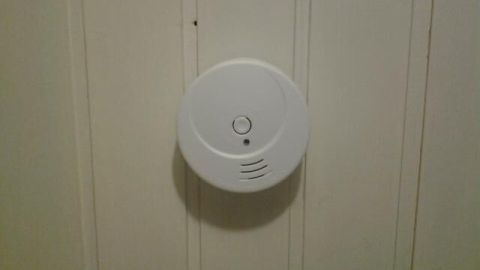 Ein Rauchmelder ist an einer hellen Wand montiert und wartet darauf, Rauch zu erkennen, um Sicherheit im Wohnraum zu bieten.