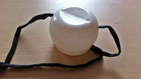 Ein runder Schnürsenkelbinder liegt auf einem Tisch, bereit, Kindern das Schnürsenkelbinden zu erleichtern.