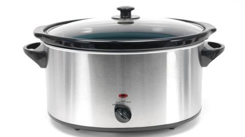 Ein Edelstahl-Slow-Cooker steht auf einer Arbeitsfläche und ist bereit, verschiedene Zutaten langsam zu garen.