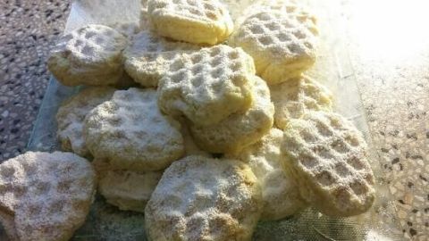 Kekse aus dem Waffeleisen liegen auf einem Teller, gut sichtbar und leicht angestrahlt von natürlichem Licht.