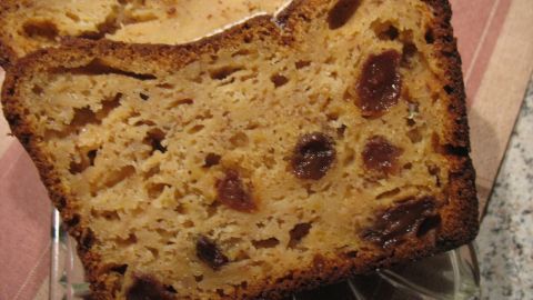 Saftiger Rührkuchen mit Äpfeln und Marzipan liegt auf einem Glasuntersetzer, während die Scheiben appetitlich angeordnet sind.
