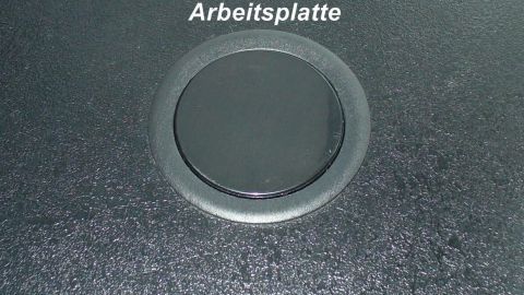 Eine versenkbare Steckdosenleiste im Tisch integriert, sichtbar auf der Arbeitsplatte, bereit zur Nutzung. Auf der Arbeitsplatte.