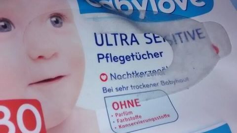 Die Packung mit babylove Ultra Sensitive Pflegetüchern schützt gereizte Haut. Sie liegt auf einem weichen Untergrund.