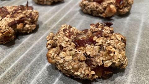 Haferflocken-Bananen-Kekse liegen frisch gebacken auf Backpapier, bereit zum Genießen. Gesund und vegan, ideal für Snacks.