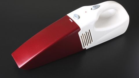 Der rote Dustbuster Akkusauger steht auf einem schwarzen Hintergrund und ist bereit, Staub und Schmutz aufzunehmen.