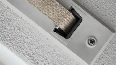Ein Rollladengurt liegt in einer Wandöffnung und zeigt Verschmutzungen, die entfernt werden sollen.
