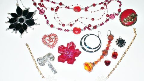 Bunte, glänzende Schmuckstücke liegen ordentlich auf einem weißen Untergrund, bereit zum schönen Verzieren von Geschenken.