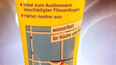 Eine Tube Pufas Fugen-Reparatur in Weiß steht auf schwarzem Untergrund. Sie beschreibt die Anwendung zur Verbesserung von Fliesenfugen.