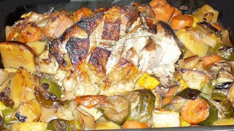 Köstliche Putenschenkel liegen gebräunt auf einem Bett aus buntem Gemüse und Kartoffeln, frisch aus dem Backofen.