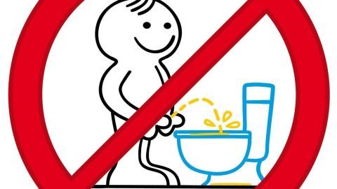 Ein durchgestrichenes Symbol zeigt einen fröhlichen Mann, der an einer Toilette urinieren möchte, veranschaulicht Stehen.