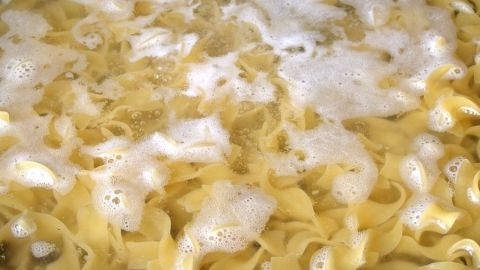 Helle Nudeln kochen in sprudelndem Wasser, wobei energetische Ressourcen während des Kochens gespart werden.