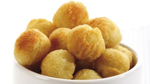 Kleine, goldbraune Kartoffelbällchen lehnen in einer weißen Schüssel, frisch zubereitet und appetitlich.
