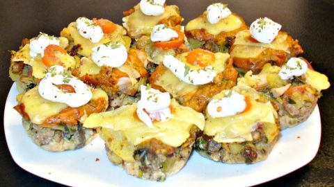Miniaturisierte Resteessen aus der Muffinform sind liebevoll angerichtet, mit Sahne und Kräutern auf einem weißen Teller.
