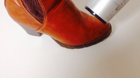 Eng anliegende Lederschuhe werden mit einem Haartrockner erwärmt, um sie zu weiten und angenehmer zu machen.