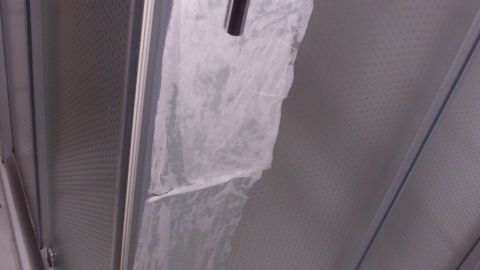 Kalkablagerungen befinden sich an einer Duschwand, während der Raum sauber und ausgestattet mit Fliesen ist.