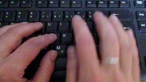 Hände tippen schnell auf einer Tastatur im Büro, während die Pflege der Haut durch regelmäßiges Eincremen wichtig ist.