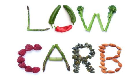 Bunte Gemüse- und Nussstücke formen den Schriftzug "LOW CARB", der auf eine gesunde Ernährung hinweist.