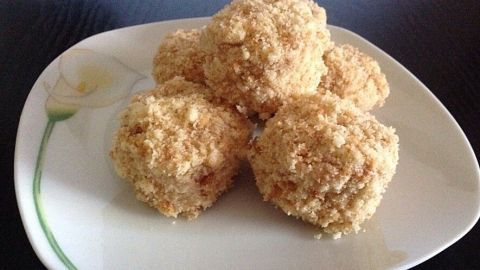 Runde, goldene Igelchen aus Teig liegen auf einem weißen Teller und erinnern an leckere Loschik, perfekt für den Genuss.