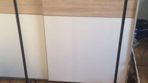 Ein schwarzer Handtuchhalter steht in einem Raum, bereit, ein nasses Handtuch zum Trocknen aufzuhängen.