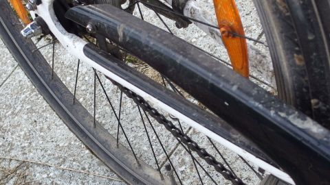 Ein Fahrrad mit einer sauberen Kette und einem klaren Kettenblatt steht auf einem befestigten Untergrund, bereit für die Fahrt.