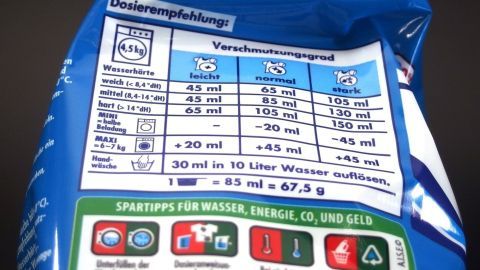 Eine Waschmittelverpackung zeigt die Dosierungshinweise für verschiedene Wasserhärten, um richtige Dosierung zu gewährleisten.