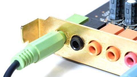 Ein grünes Kabel wird in den Ausgang einer Soundkarte eingesteckt, um Brummschleifen zur Stereoanlage zu vermeiden.