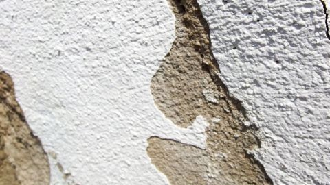 Eine bröselige Wand zeigt Stellen mit abblätterndem Putz, was eine Herausforderung beim Befestigen von Schrauben darstellt.