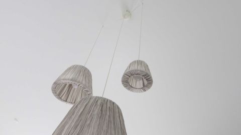 Durch eine Taschenlampe in der Mitte eines Tisches lässt sich der Bohrer an der Decke so ansetzen, dass die künftige Lampe zentriert über dem Tisch hängt. Drei schicke Deckenlampen hängen unter der Decke, bereit, präzise über einem Tisch positioniert zu werden.