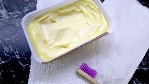 Mithilfe von Margarine lassen sich Felgen hervorragend reinigen. Eine Packung Margarine liegt auf einem Tuch, neben einer Zahnbürste, bereit zum Reinigen von Felgen.