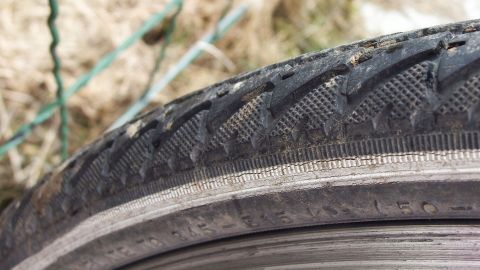 Ein Fahrradschlauch liegt sichtbar auf dem Boden, bereit zum Flicken mit Sekundenkleber in einer natürlichen Umgebung.