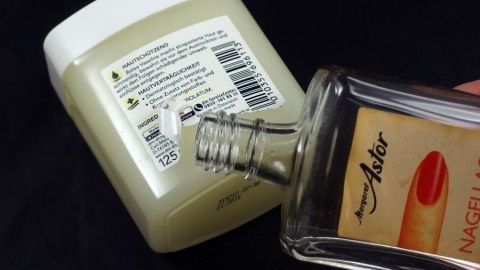 Eine Flasche mit Lösungsmittel wird über eine Creme-Dose gehalten, um Klebereste von Plastik zu entfernen.