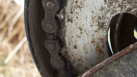 Schwer zu reinigende Hände sauber bekommen, ohne chemisch bedenkliche Lösungsmittel verwenden zu müssen. Eine verschmutzte Kette an einem Rad dreht sich schwerfällig in einer staubigen Umgebung, überzogen mit schwarzem Fett.