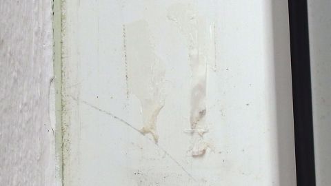Eine Wand mit Kunststoffen zeigt Kleberreste, während der Bereich um die Stelle sauber und unbeschädigt wirkt.