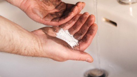 Ölverschmierte Hände mit Waschpulver reinigen