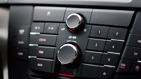 Toller Glanzeffekt für schwarze Armaturen im Auto, mit einem einfachen Schuhcremeschwamm. Ein glänzendes Armaturenbrett mit Reglern und Knöpfen, die für Musik und Einstellungen im Fahrzeug verwendet werden.