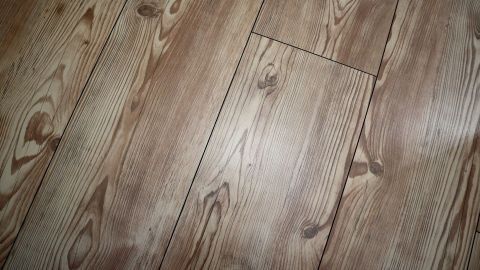 Der Laminatboden zeigt eine hellbraune, holzähnliche Oberfläche, die in einer modernen Küche als stilvoller Fliesenspiegel wirkt.
