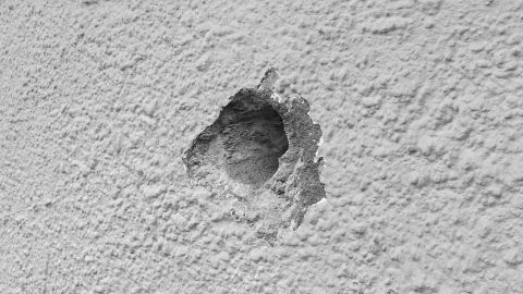 Ein präzises Bohrloch in einer strukturierten Wand zeigt saubere Kanten ohne Ausfransungen, ideal für Befestigungen.