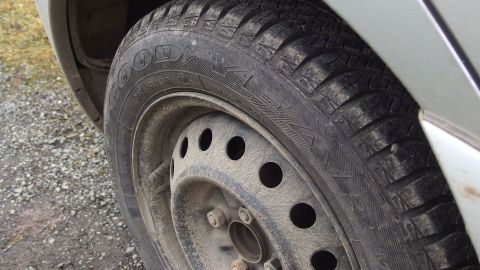 Laut ADAC sollte man die "guten" Reifen besser hinten montieren. Ein Reifen liegt auf einem Schotterweg, zeigt Abnutzungsspuren und ist auf einem Fahrzeug montiert, das sich in Bewegung befindet.