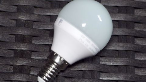 Ein LED-Leuchtmittel liegt auf einem dunklen, geflochtenen Hintergrund und könnte in einem 12V-System verwendet werden.