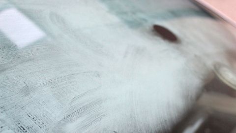 Mit diesem Trick verhindert man beschlagene Autoscheiben: Einfach Zeitungspapier auf der Fahrerseite unter die Fußmatte legen. Eine beschlagene Autoscheibe zeigt eine unklare Sicht. Das Bild verdeutlicht, wie Zeitungspapier eingesetzt werden kann, um dies zu verhindern.